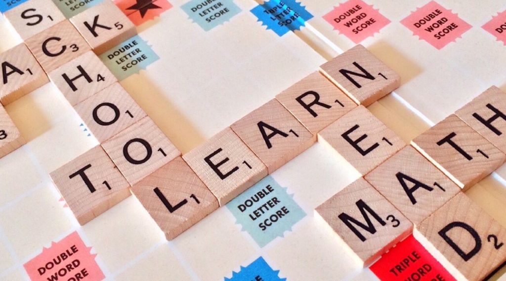 Crafting Captivating Headlines: Your awesome post title goes here Close-up of Scrabble tiles forming words related to education and school.