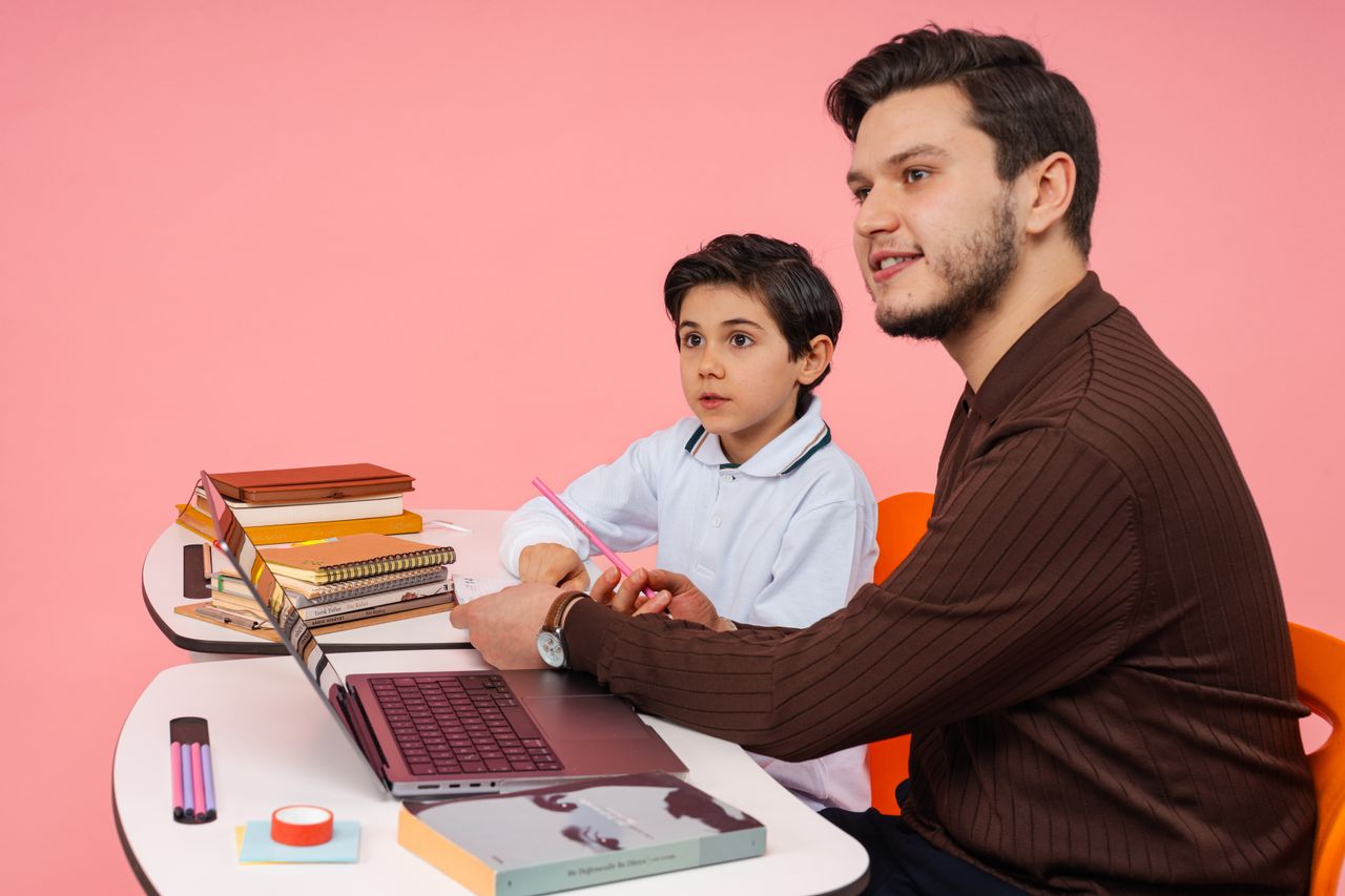 cta-01 Male teacher and young boy studying together at a desk in Yalova, Türkiye.